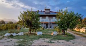 een huis met twee bomen en rotsen ervoor bij Antica Dimora dei Gelsi in Manerba del Garda