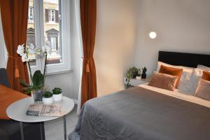 una camera con letto, tavolo e finestra di The Roman Empire Guesthouse a Roma