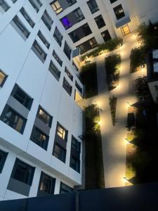widok na wysoki biały budynek z oświetleniem w obiekcie AirPort Apartment w Warszawie