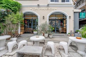 een patio met tafels en stoelen voor een winkel bij Tim Mansion in Bangkok