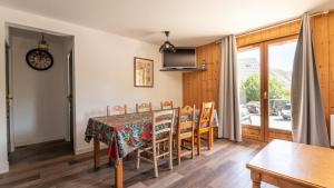 una sala da pranzo con tavolo e sedie di Les Marmottes-32- 10 pers a Saint-Sorlin-dʼArves Altre 9 foto