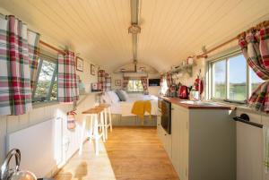 una cocina y un dormitorio en una casa pequeña en The Shepherd's Shed at Accott Manor, 
