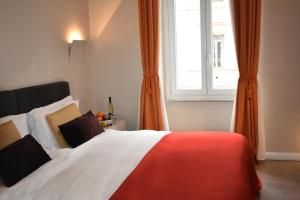 a bedroom with a bed with orange curtains and a window at The Roman Empire Guesthouse in Rome