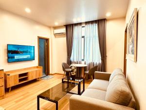 a living room with a couch and a tv at Warm & Cozy Apartment in Hai Phong