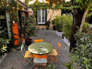 patio ze stołem, krzesłami i roślinami w obiekcie VILLA RENEE w mieście Valence