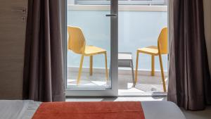 a bedroom with two chairs on a balcony at Alavits Hotel by ST Hotels in Il-Gżira