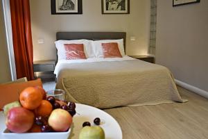 a bedroom with a bed and a bowl of fruit on a table at The Roman Empire Guesthouse in Rome