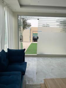 a living room with a blue couch and a screen at شالية السحاب in Al Ḩazm