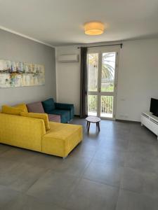 a living room with a yellow couch and a tv at casa verdemare in Cefalù