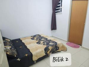 Rantau PanjangにあるRo-z Homestayのベッドルーム(キルト付きのベッド付)