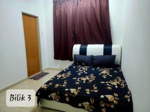 um quarto com uma cama com um edredão preto e branco em Ro-z Homestay em Rantau Panjang