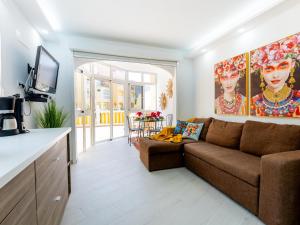 een woonkamer met een bruine bank en een tafel bij 9 Parque Tropical Apartamento Los Cristianos in Los Cristianos