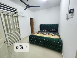 um quarto com uma cama verde num quarto em Ro-z Homestay em Rantau Panjang