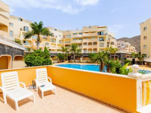 einen Balkon mit Stühlen und einem Pool in der Unterkunft 9 Parque Tropical Apartamento Los Cristianos in Los Cristianos