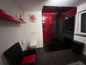 a bathroom with a red shower in a room at Großzügige Ferienwohnung im Oberland in Warngau
