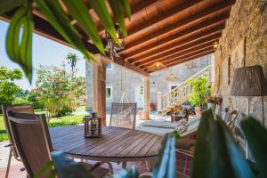 Un patio al aire libre con una mesa y sillas de madera. en La casa de los Barbazanes, en Brión