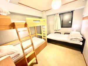 a room with two bunk beds and a window at TenTen Guesthouse in Asakusa in Tokyo