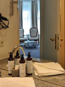 a bathroom counter with three bottles of soap on it at Hotel Villa Carlton - Adults Only in Salzburg