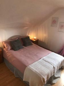 a bedroom with a large bed with two pillows at Rockgardencottage in Lettermacaward