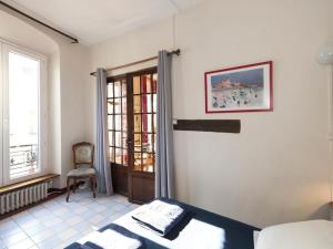 Latin Quarter - Notre Dame apartment في باريس: غرفة نوم بسرير وكرسي ونافذة