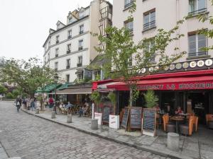 パリにあるラテン クオーター - ノートル ダム アパートメントのテーブル席のレストランのある通り