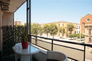 una mesa y sillas en un balcón con vistas a la calle en L.T. Savoia Palace & Cavour C.L., en Bari