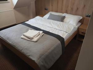 Una cama con dos toallas encima. en Makarewicz Dworek, en Szypliszki