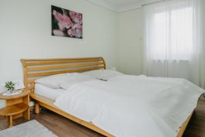 a bedroom with a bed with white sheets and a table at Ferienwohnung Morgensonne in Schützen am Gebirge