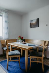 a dining room table with two chairs and a wooden table at Ferienwohnung Morgensonne in Schützen am Gebirge