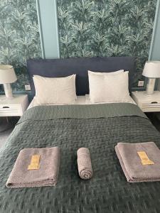 a bedroom with a bed with two towels on it at Pokoje na Pańskiej 9 in Gdańsk