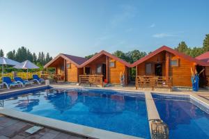 a log cabin with a swimming pool in front of it at Apartments and bungalow Casa Palma in Ulcinj +45 photos