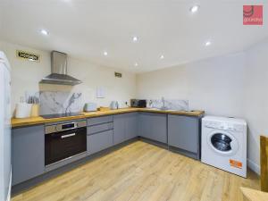 a kitchen with a washing machine and a washer at TruroFlat in Truro