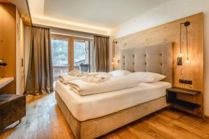 a large white bed in a room with a window at Apartmenthaus Wiesenhof in Aschau