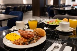 Alavits Hotel by ST Hotels في إيل جزيرا: طاولة مع طبقين من الطعام وكأسين من عصير البرتقال