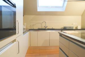 eine Küche mit einem Waschbecken und einem Fenster in der Unterkunft Le Tropical, Chic & Design in Wahlbach