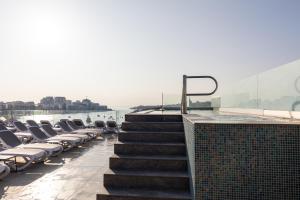 a row of lounge chairs on the roof of a building at Alavits Hotel by ST Hotels in Il-Gżira