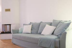 eine graue Couch mit zwei weißen Kissen drauf in der Unterkunft Le Tropical, Chic & Design in Wahlbach