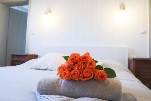 ein Strauß orangefarbener Rosen auf dem Bett in der Unterkunft Le Tropical, Chic & Design in Wahlbach