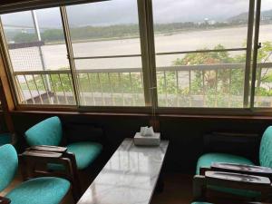 een tafel en stoelen in een kamer met een raam bij 桂浜龍馬に1番近い宿ペットと泊れる一軒家龍馬庵 in Kochi