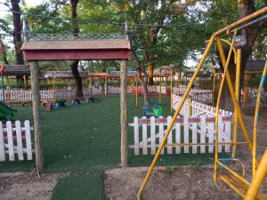 un parque con parque infantil con una valla blanca en Тур центр Вилящ en Masallı