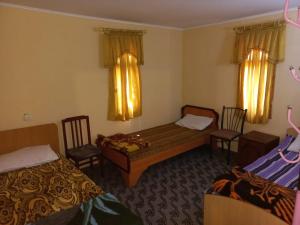 a hotel room with two beds and two chairs at Тур центр Вилящ in Masallı