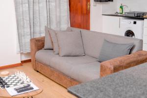 sala de estar con sofá y tablero de ajedrez en Entire 2 Bed, 5 mins 2 Game City, Netflix & Ps4, en Gaborone