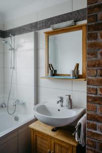 a bathroom with a sink and a mirror and a tub at Ferienwohnung Morgensonne in Schützen am Gebirge