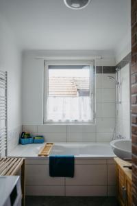 biała łazienka z wanną i oknem w obiekcie Ferienwohnung Morgensonne w mieście Schützen am Gebirge