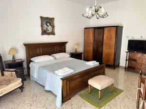 Schlafzimmer mit einem Bett, einem TV und einem Stuhl in der Unterkunft Elico Di Sicily B@B in Sambuca di Sicilia