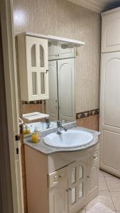 Baño blanco con lavabo y espejo en Appartement spacieux et agréable en Tánger