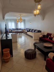 salon z kanapą i stołem w obiekcie Appartement spacieux et agréable w mieście Tanger