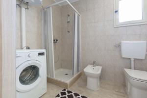 a bathroom with a washing machine and a toilet at Villetta Paola by BarbarHouse in Borgagne +33 photos
