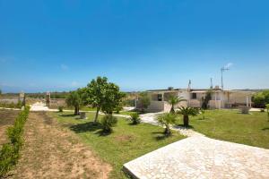 a yard with trees and a building in the background at Villetta Paola by BarbarHouse in Borgagne