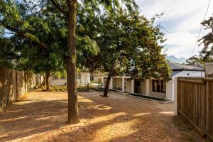 a brick driveway in front of a house with trees at The Cottage in the Valley - 3 bedroomed in Riebeek-Kasteel